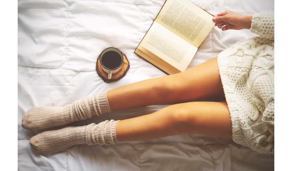 coffee, a book, and a woman on a bed