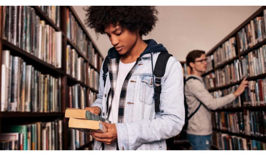 man looking at books