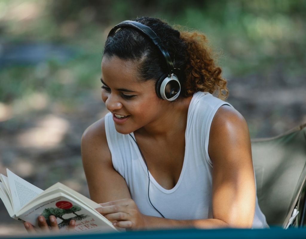 woman reading with headphones on reading a book