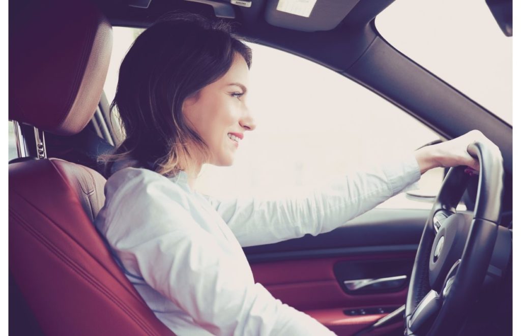 woman driving car listening to audiobook