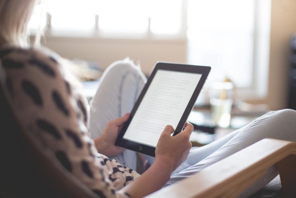 woman reading e-book in chair